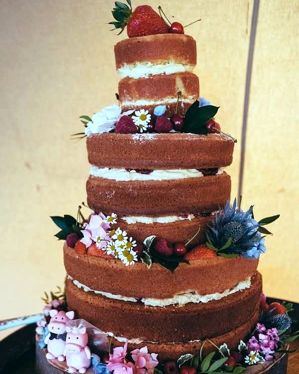 Five-tier naked sponge cake with strawberries, flowers and thistles