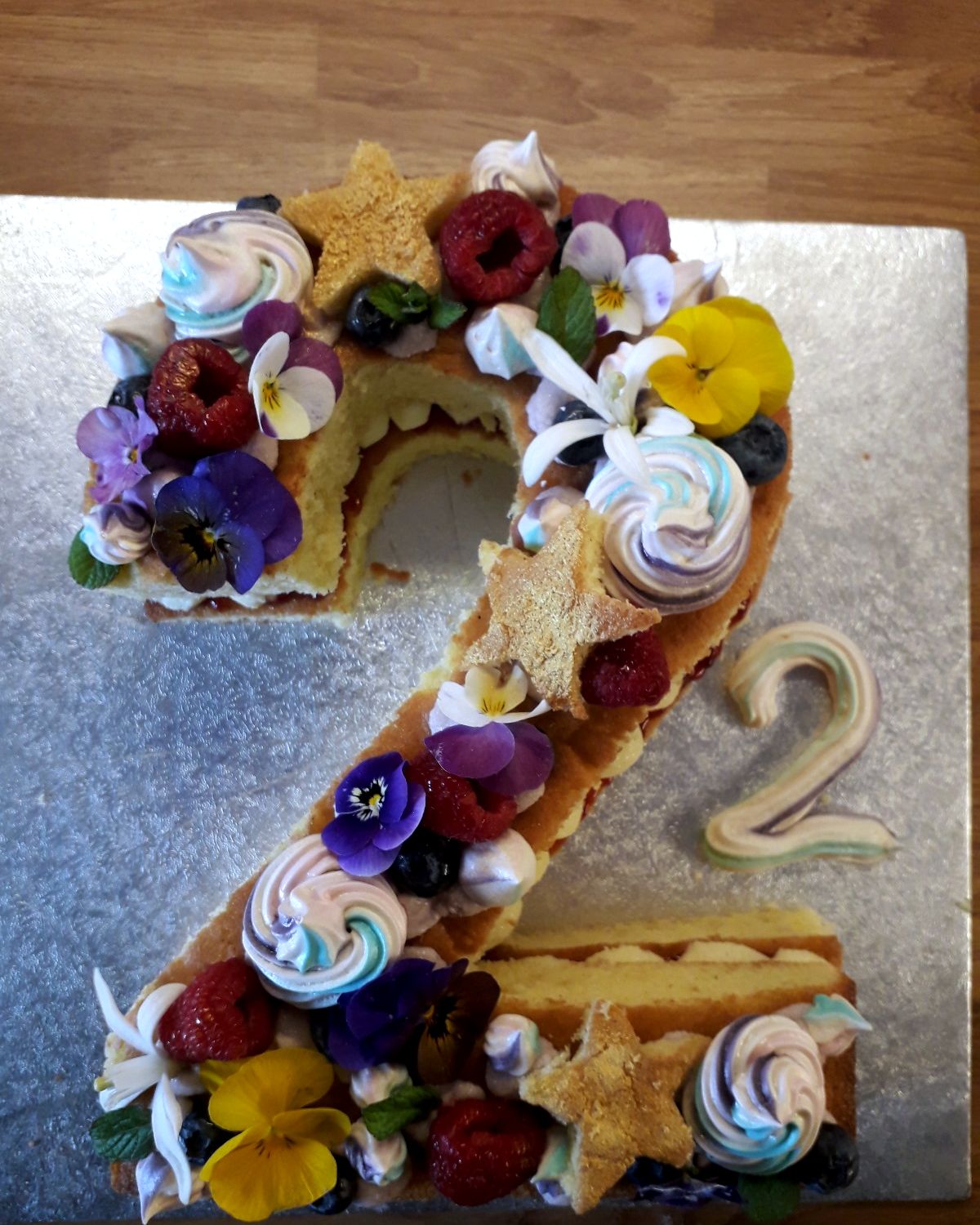 Number 2 cake with meringues, berries, edible flowers and pastry stars