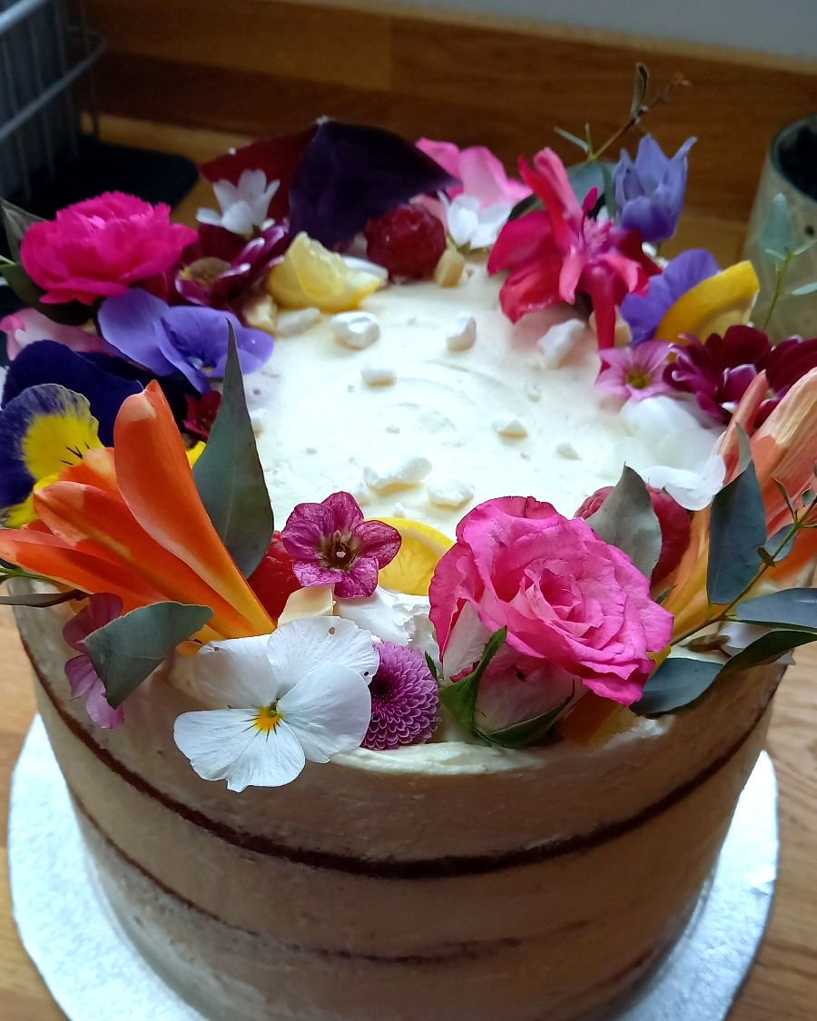 Chocolate-sided cake topped with roses, pansies and lilies